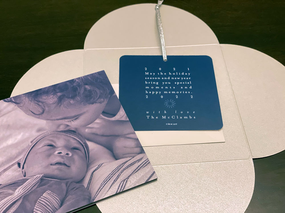 A modern, custom petal square enclosure opens to baby announcement and holiday greeting ornament.
