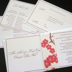 A contemporary, cherry blossom inspired custom wedding invitation set with inserts and reply postcard.