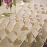 A minimalist, purple and silver custom wedding place cards displayed on table for guests.